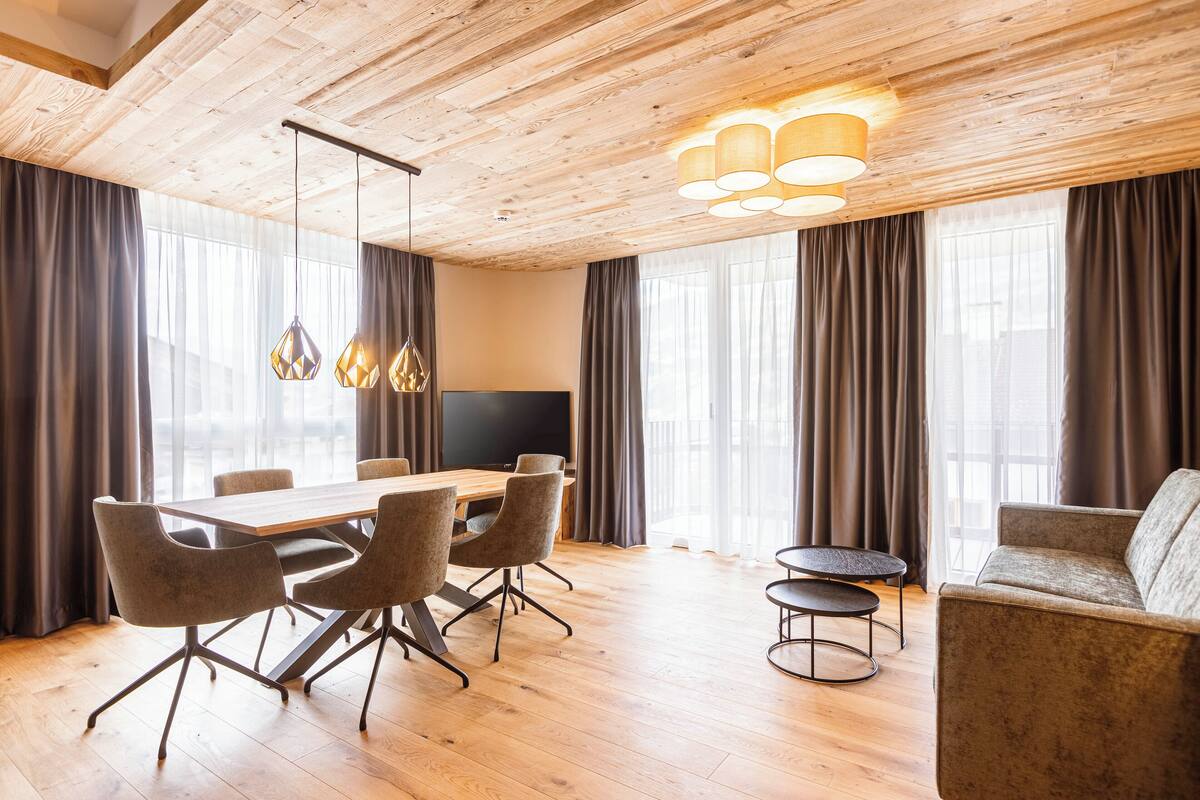 Una sala de conferencias moderna con una mesa de madera, sillas y un sofá.