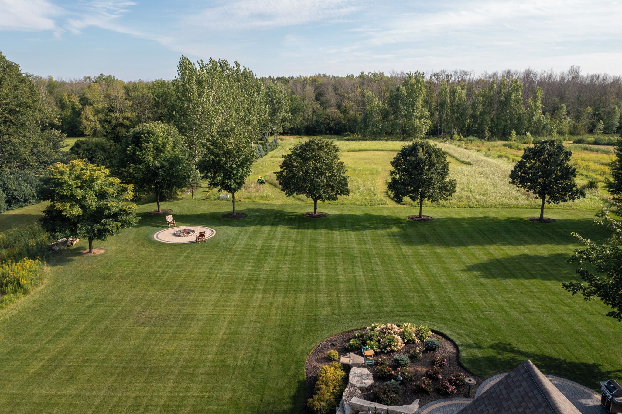 Un terrain de golf bien entretenu, doté d’un espace de putting circulaire, entouré d’arbres luxuriants et surplombé d’un ciel dégagé.