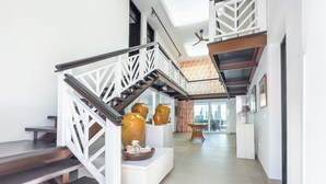 A modern interior with a staircase, white railings, and a ceiling fan.