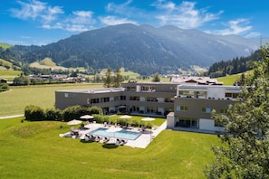 A modern hotel with a swimming pool, outdoor seating, and a view of mountains. - Tauernresidence Radstadt by ALPS RESORTS (Radstadt)