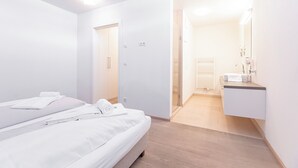 Una habitación de hotel moderna con cama, baño y vestidor.