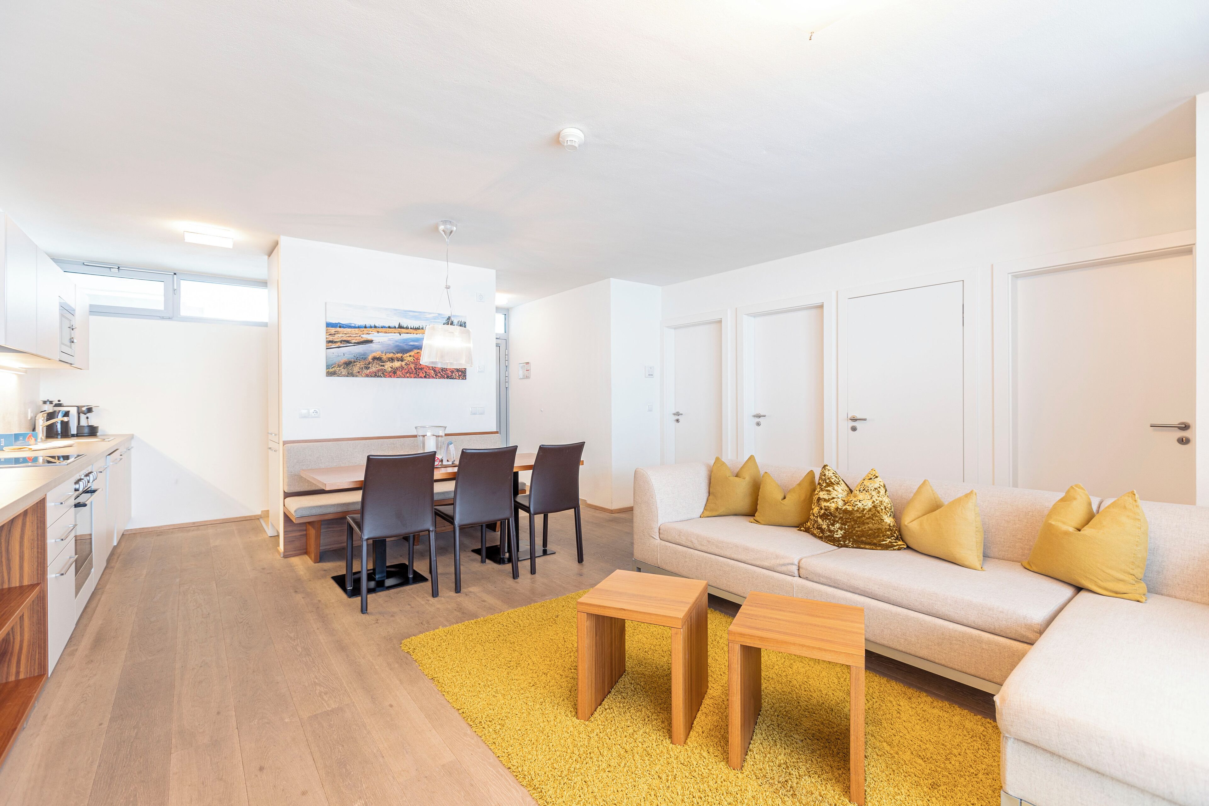 Un salon moderne avec un canapé, une table basse et un coin repas.