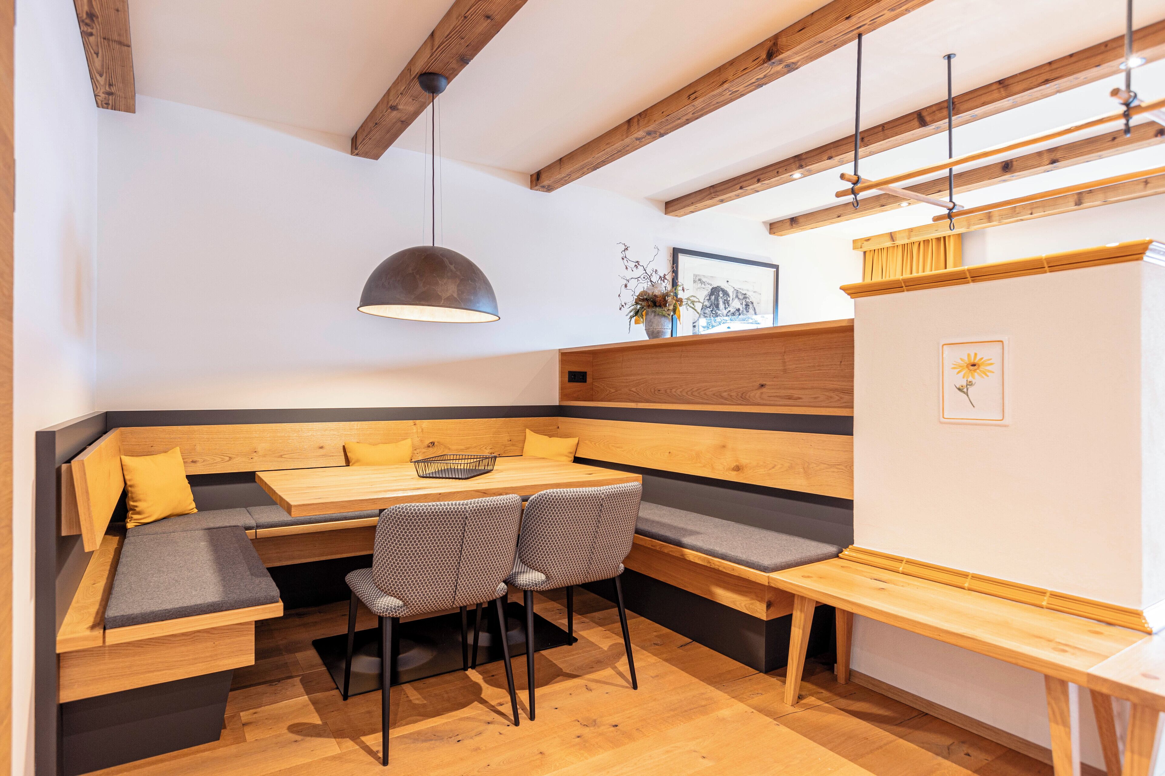 A modern dining area with a wooden bench seating, a table, and chairs.