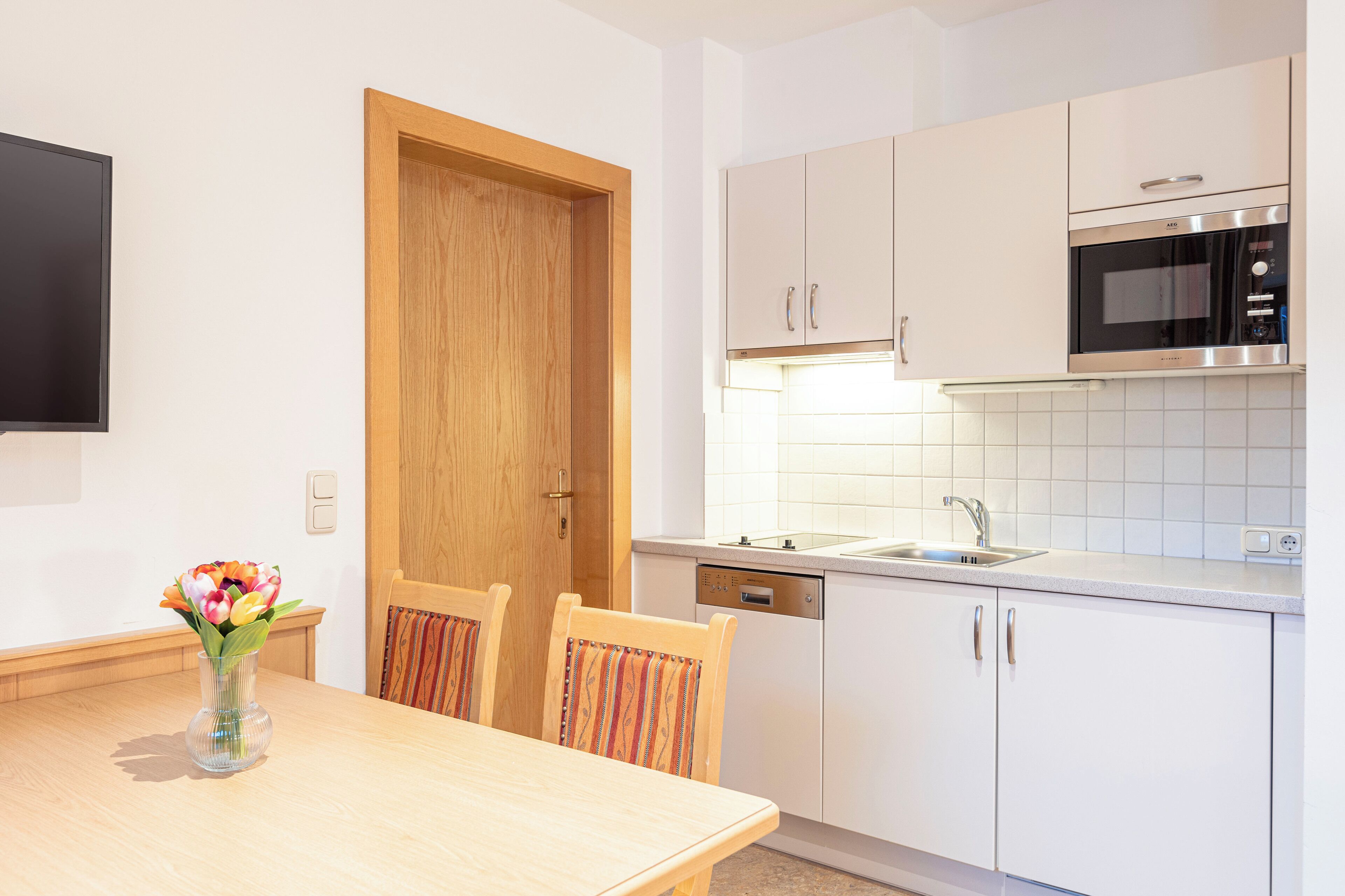 Una cucina moderna con mobili bianchi, forno integrato e lavastoviglie.