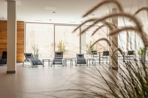 Um interior moderno com uma grande janela, uma parede de madeira e várias poltronas.