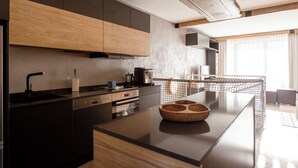 Une cuisine moderne avec des meubles en bois, un plan de travail noir et un four encastré.