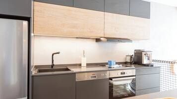 Eine moderne Küche mit Edelstahlgeräten, Holzschränken und einem eingebauten Backofen.
