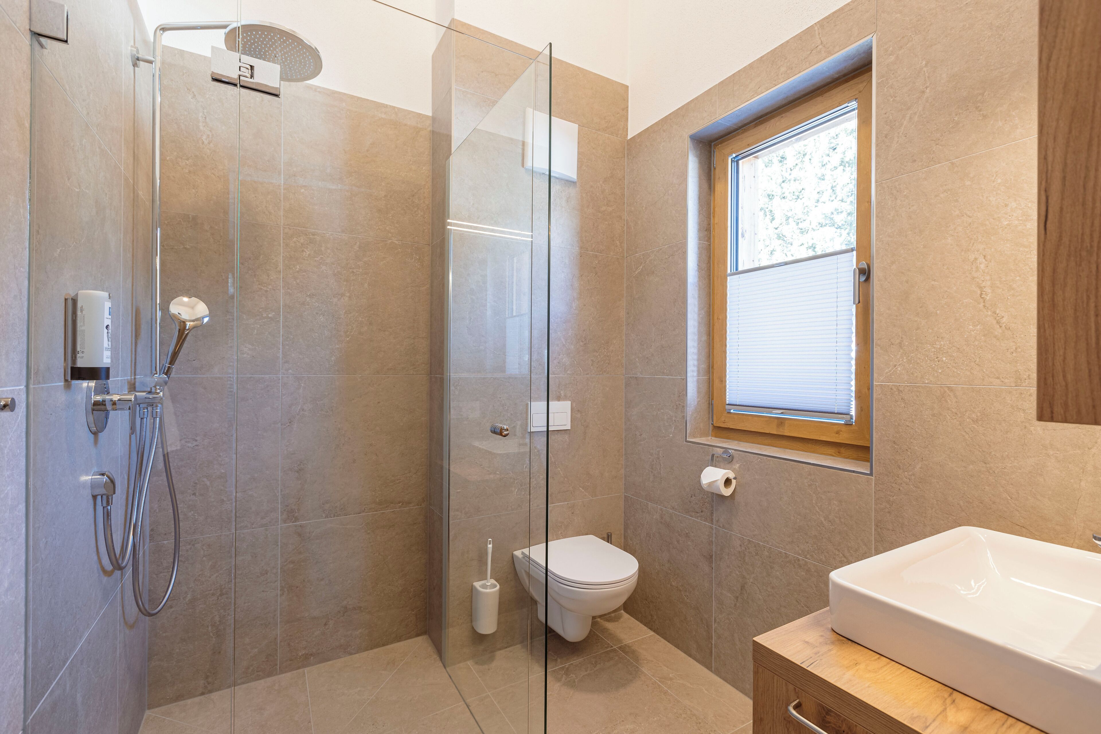 Ein modernes Badezimmer mit einer Duschkabine, einer Toilette und einem Waschbecken.