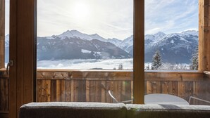 Eine Holzterrasse mit Blick auf schneebedeckte Berge.