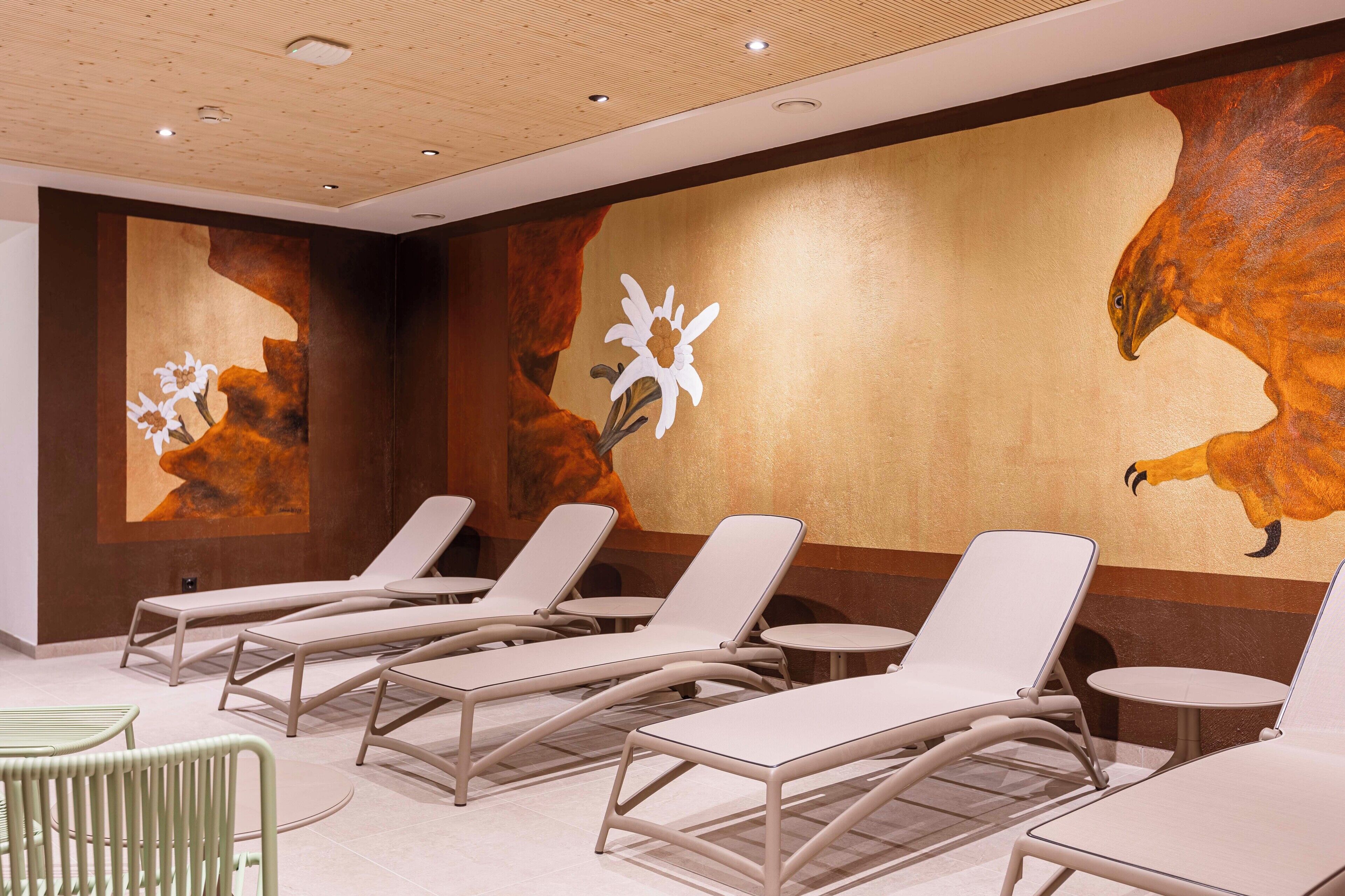 A spa area with lounge chairs and a wall mural.