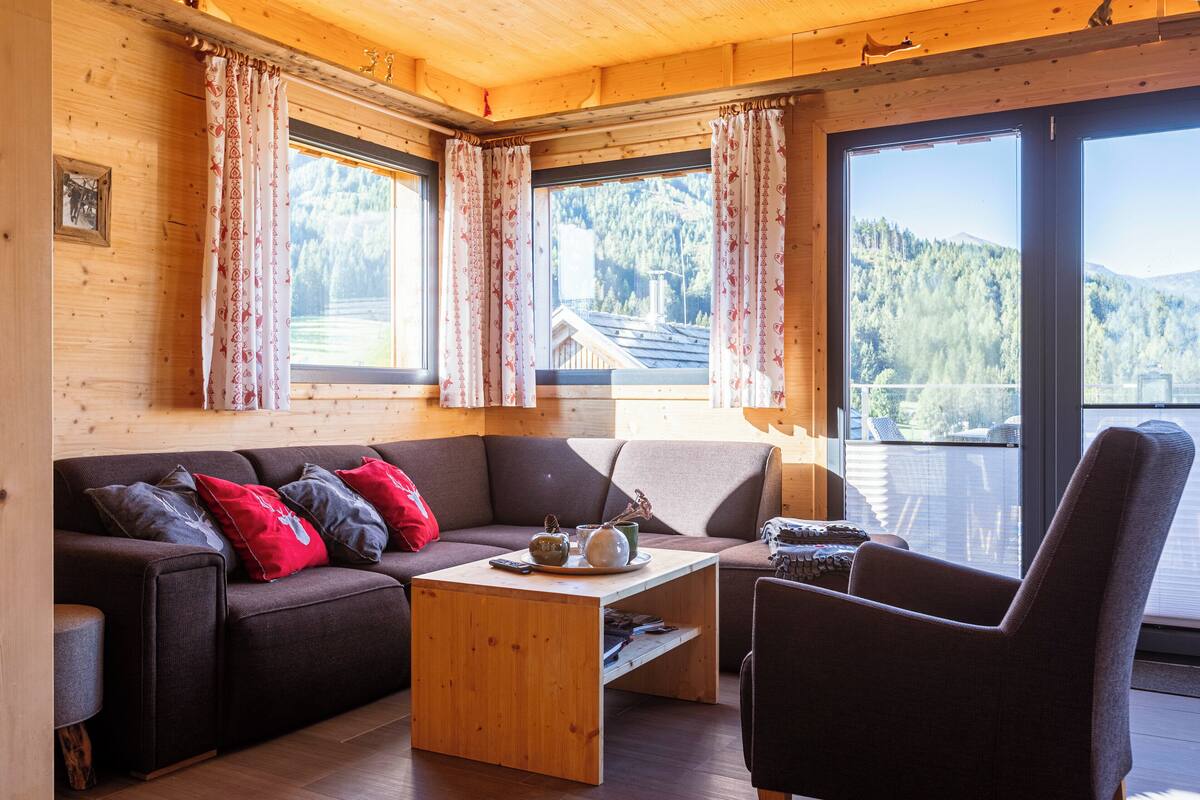 Un acogedor interior de cabaña con sofá, sillón y mesa de centro.