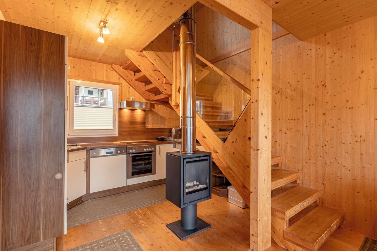 Un interior de madera con una cocina, una estufa y una escalera.