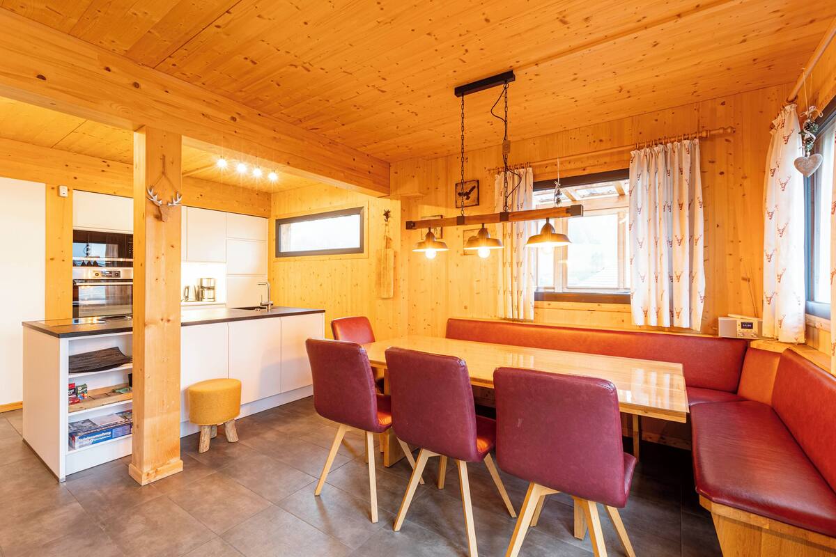 Interior de madera con comedor, cocina y zona de estar.