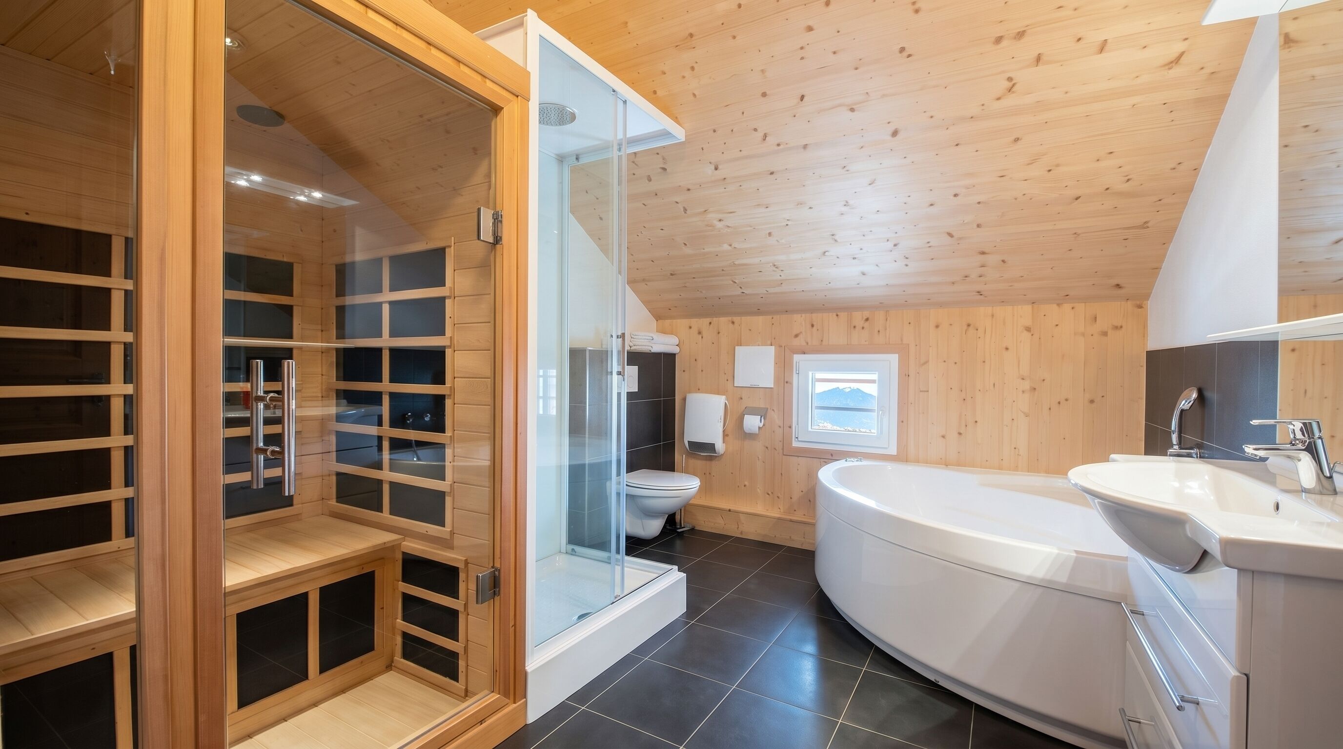 Un bagno moderno con cabina doccia in vetro, vasca da bagno bianca e servizi igienici.