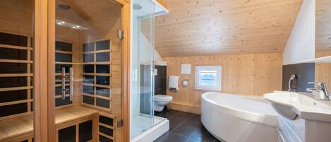 Un bagno moderno con cabina doccia in vetro, vasca da bagno bianca e servizi igienici.