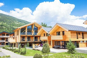 A wooden cabin-style hotel with a pool area, large windows, and a view of the mountains. - Kreischberg Pool Villas & Penthouses by ALPS RESORTS (Sankt Georgen am Kreischberg)
