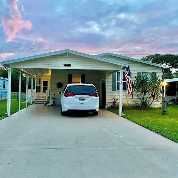 A single-story house with a covered garage and a white car parked inside.