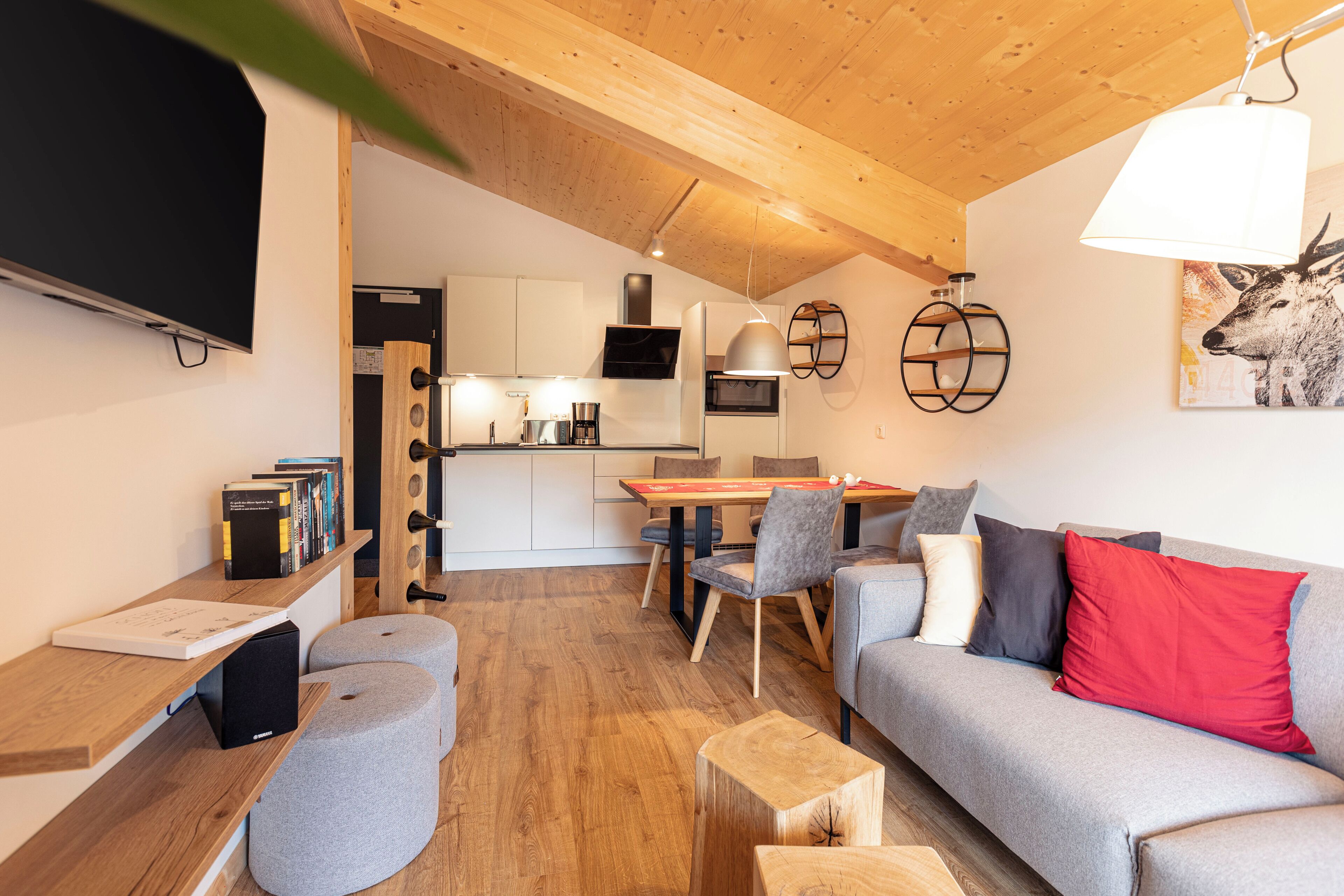 Una sala de estar moderna con un sofá gris, una mesa de centro de madera y un comedor con mesa y sillas.