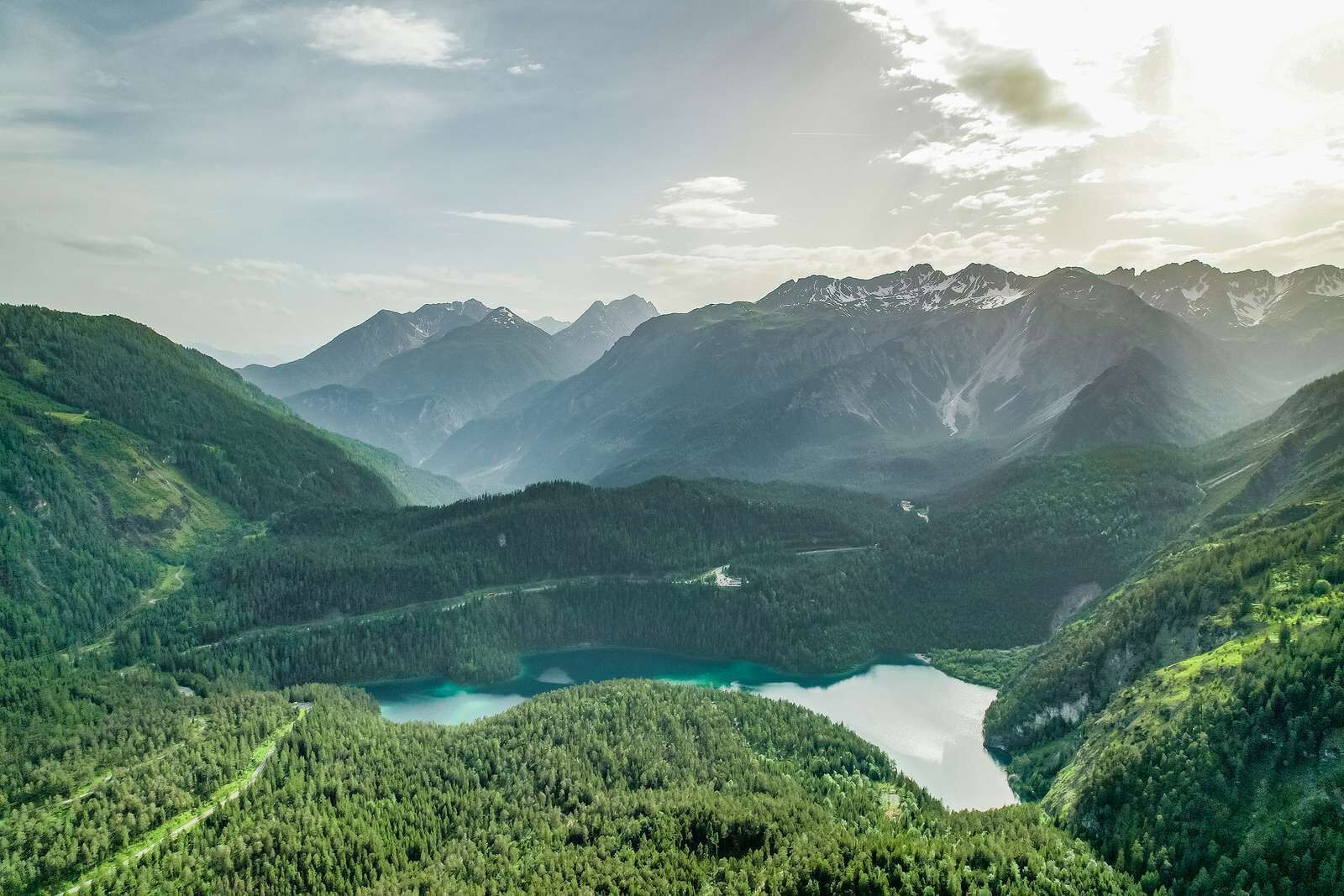 Eine Berglandschaft mit einem See und bewaldeten Gebieten.