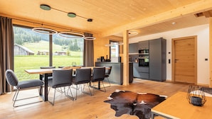 A modern kitchen with dark cabinets and a wooden ceiling. - Alpenchalets Biberwier by ALPS RESORTS (Biberwier)