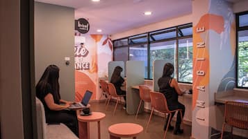 Un interior moderno con zonas de estar, una computadora portátil sobre una mesa y una pared con un logotipo.