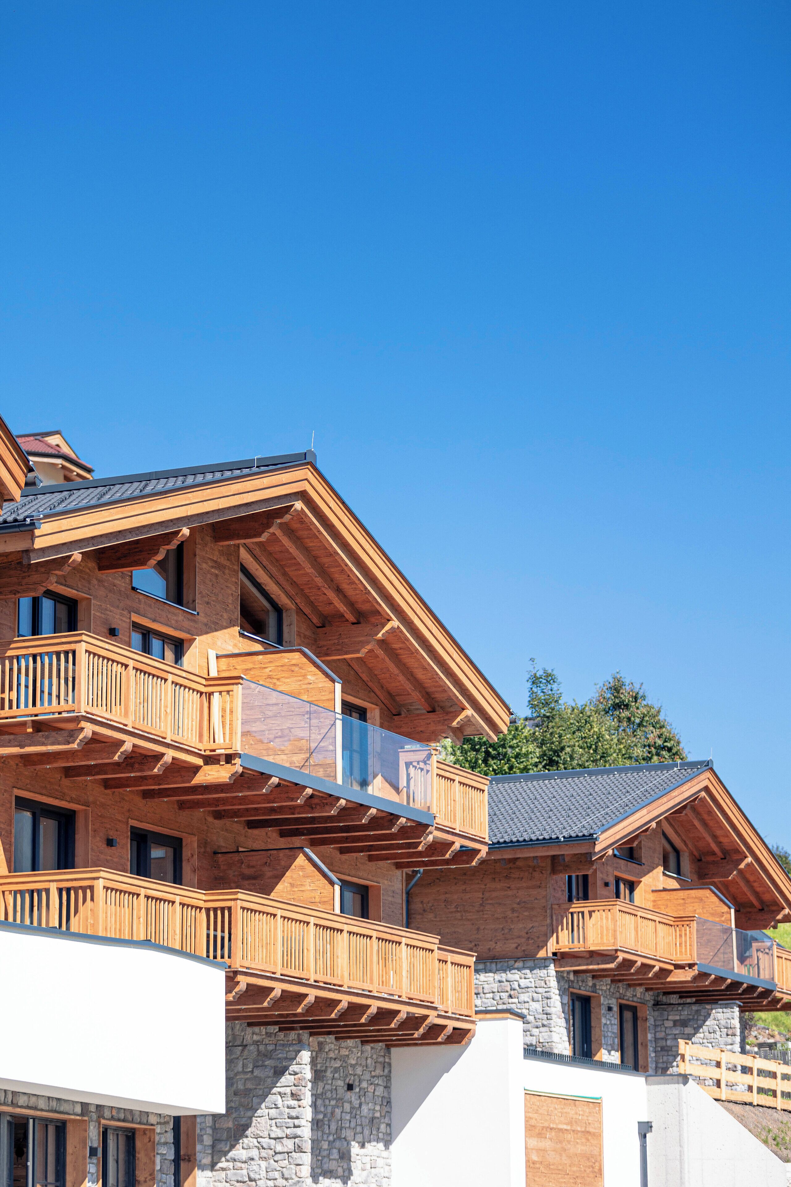 A multi-story wooden building with balconies and a stone facade.