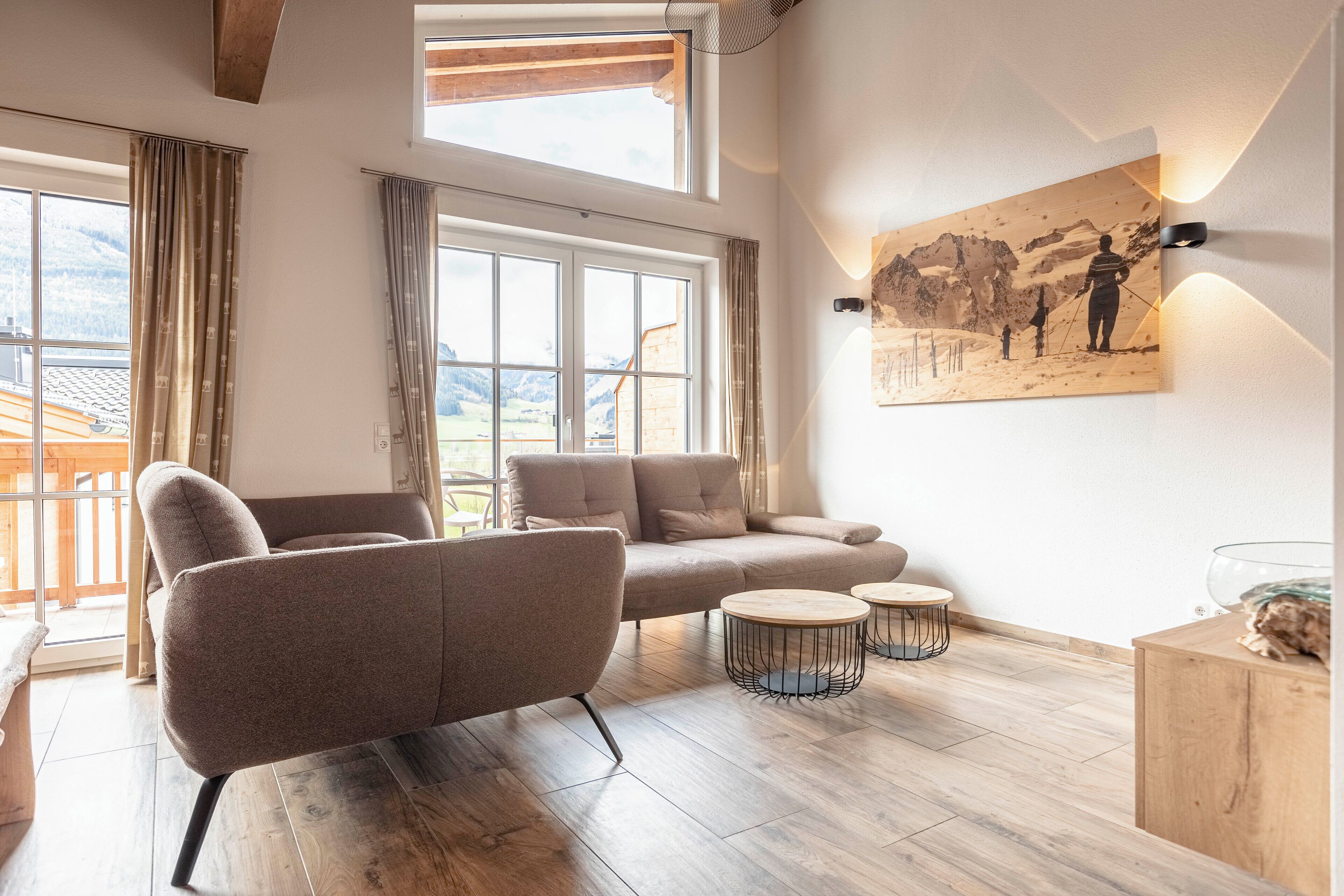A modern living room with a sofa, two side tables, and a large window with curtains.