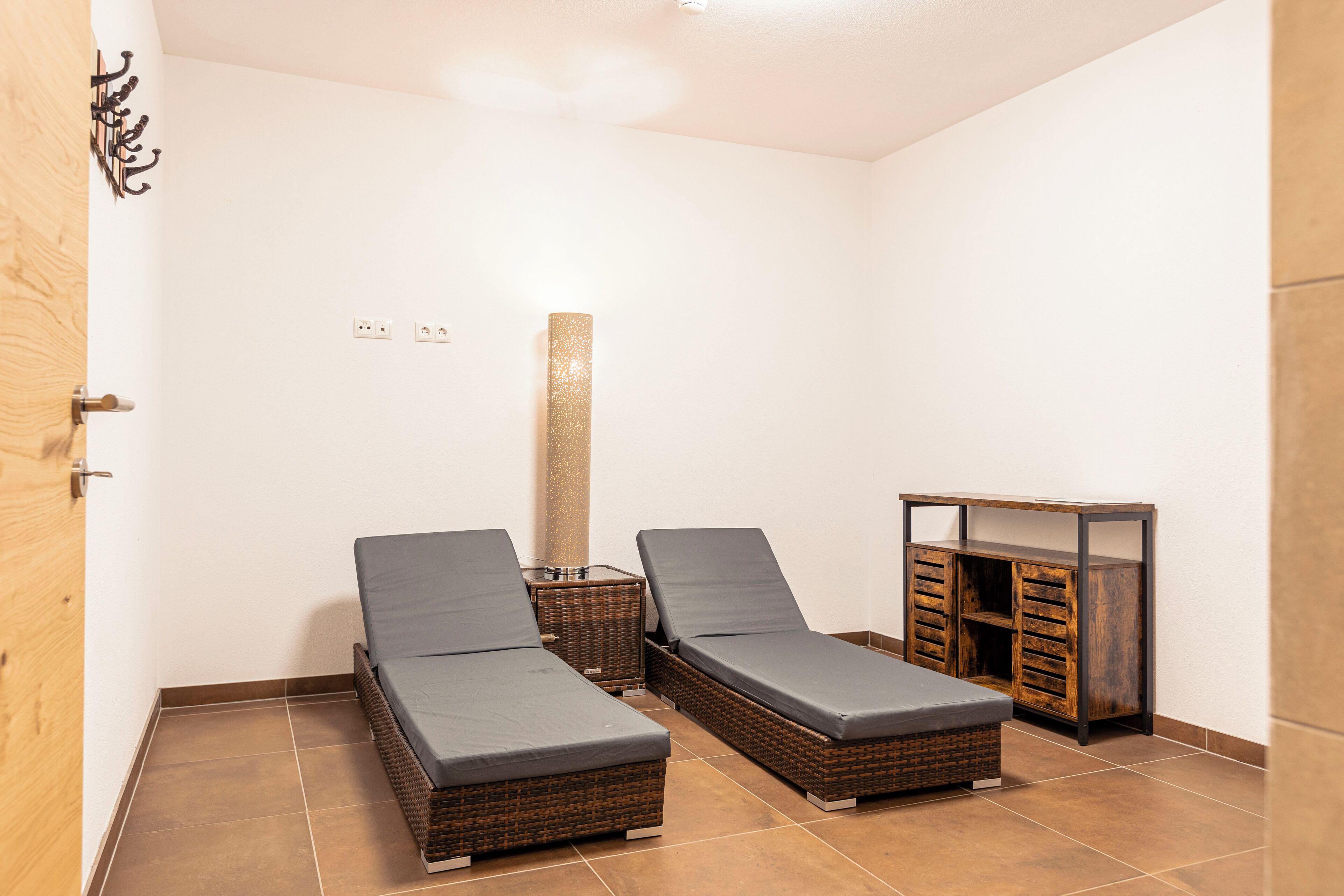 Een kamer met twee enkele bedden, een tafeltje en een kast.