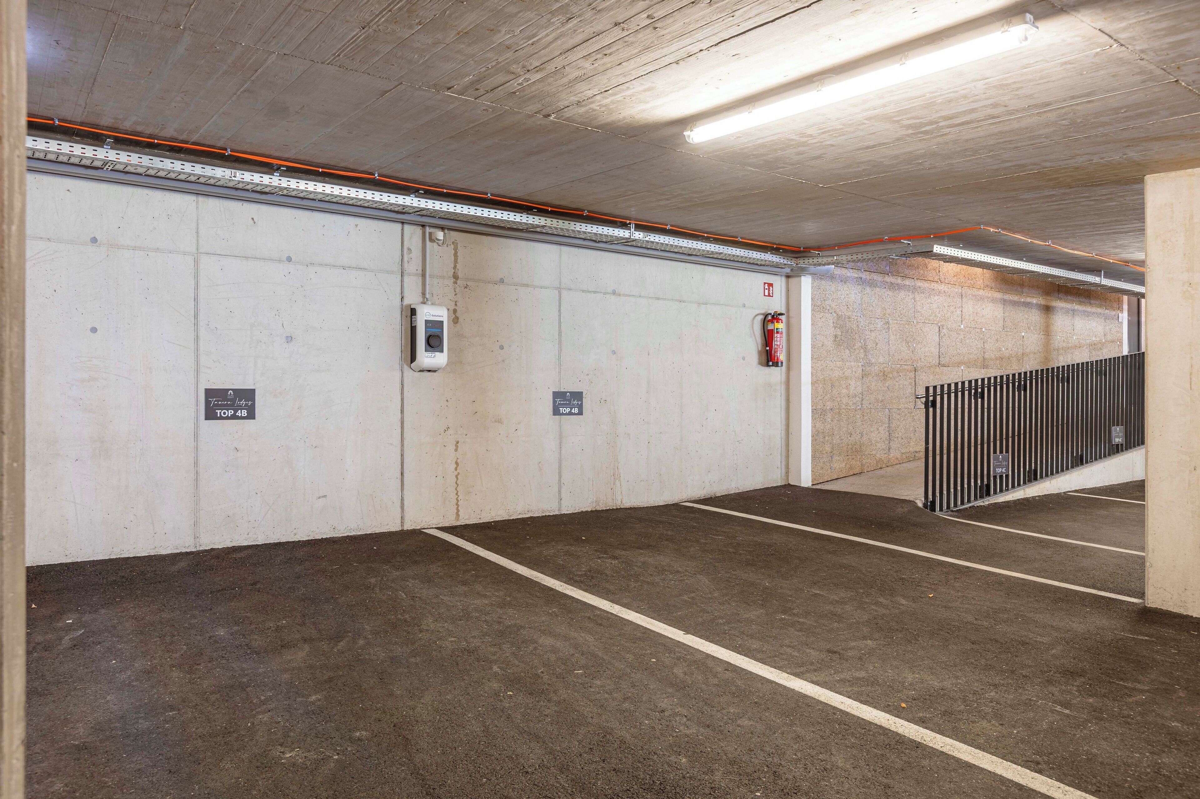Eine Parkgarage mit Betonwänden, einem Feuerlöscher und einer Überwachungskamera.