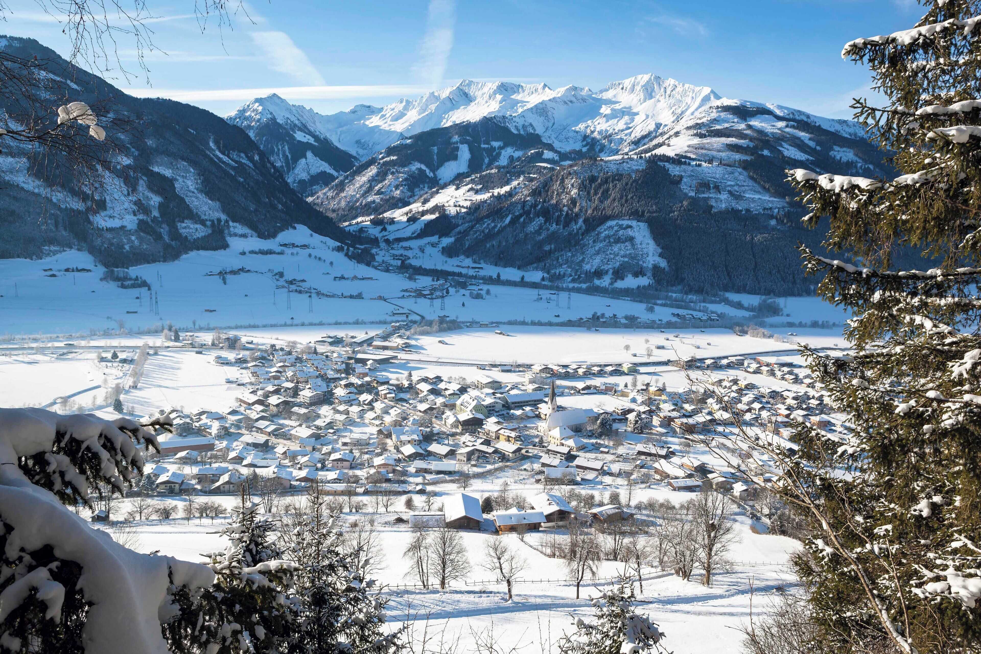 A snow-covered town with mountains in the background.