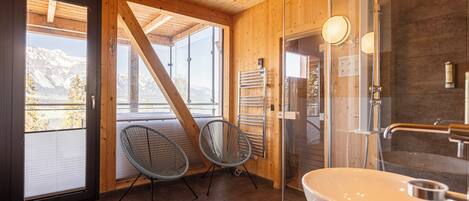 A wooden interior with a large window, a sink, and a shower.