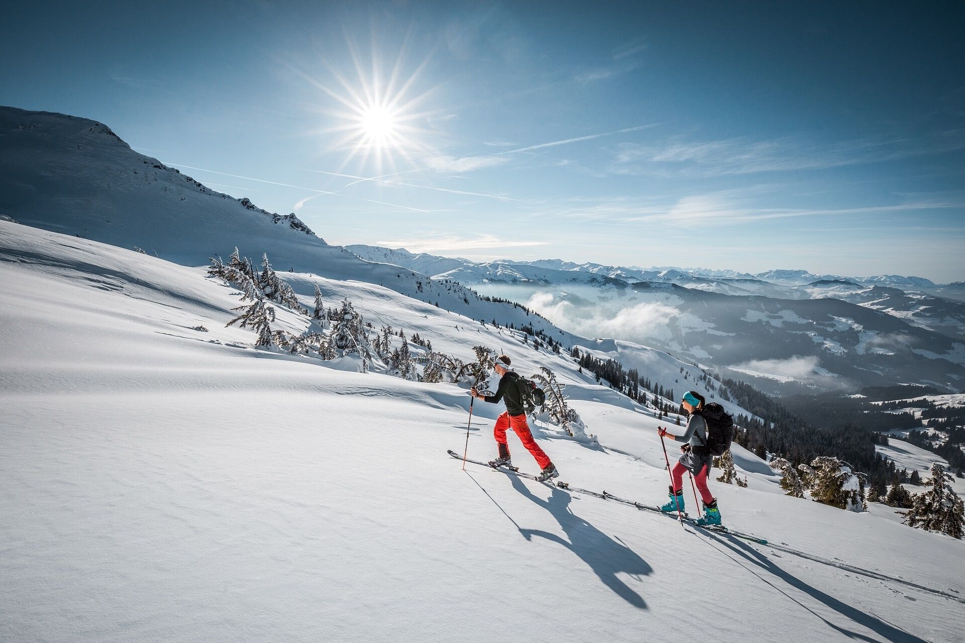 A snowy mountain landscape with skiers.