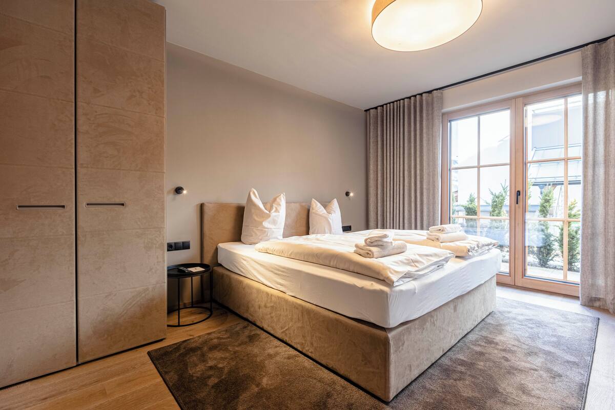 Ein modernes Schlafzimmer mit einem großen Bett, einem Nachttisch und einem Kleiderschrank.