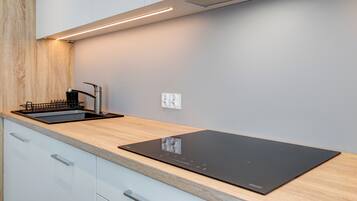 A modern kitchen with a built-in stove, a sink, and a wooden countertop.