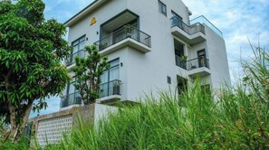Experience the serene atmosphere of this contemporary building, surrounded by lush greenery and offering stunning views from the upper-floor balconies.