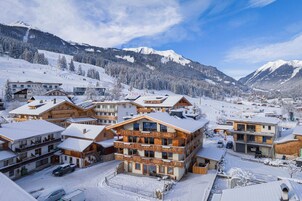 A snow-covered mountain town with wooden buildings and a ski slope in the background.