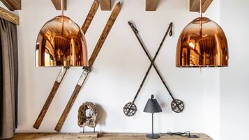 A wooden table with skis, a lamp, and a wall-mounted light fixture.