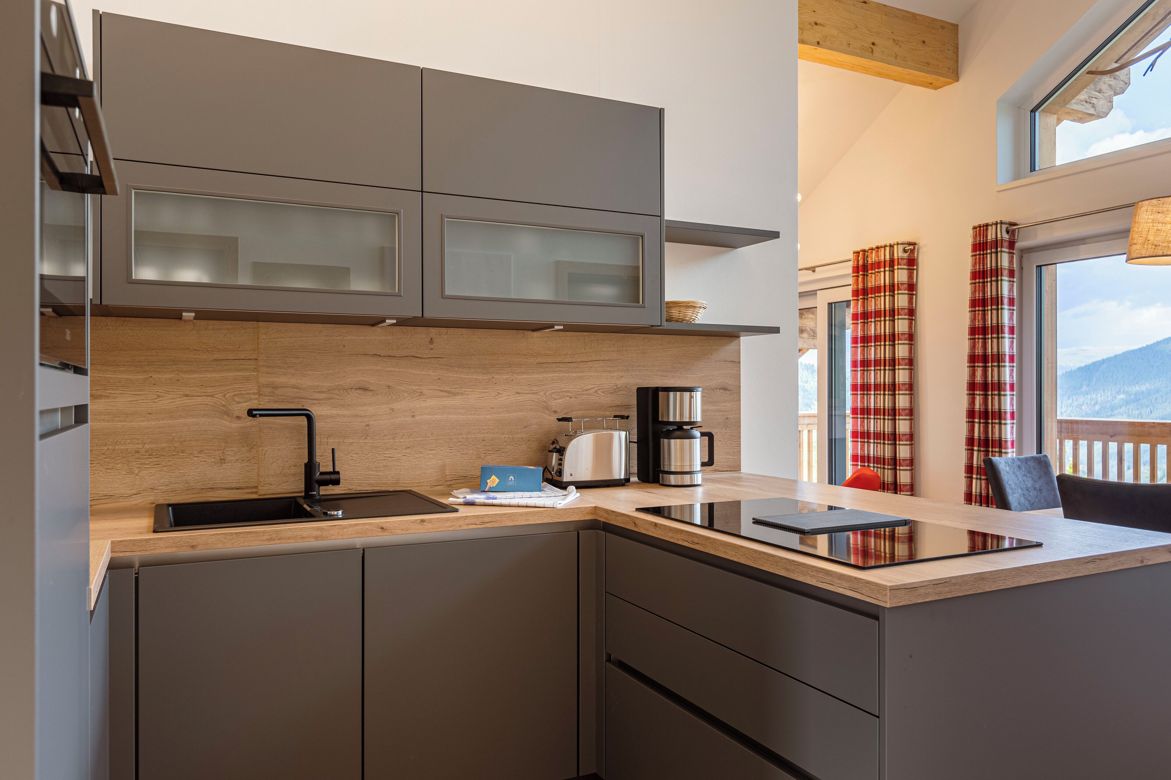 A modern kitchen with a wooden countertop, a built-in sink, and a coffee maker.