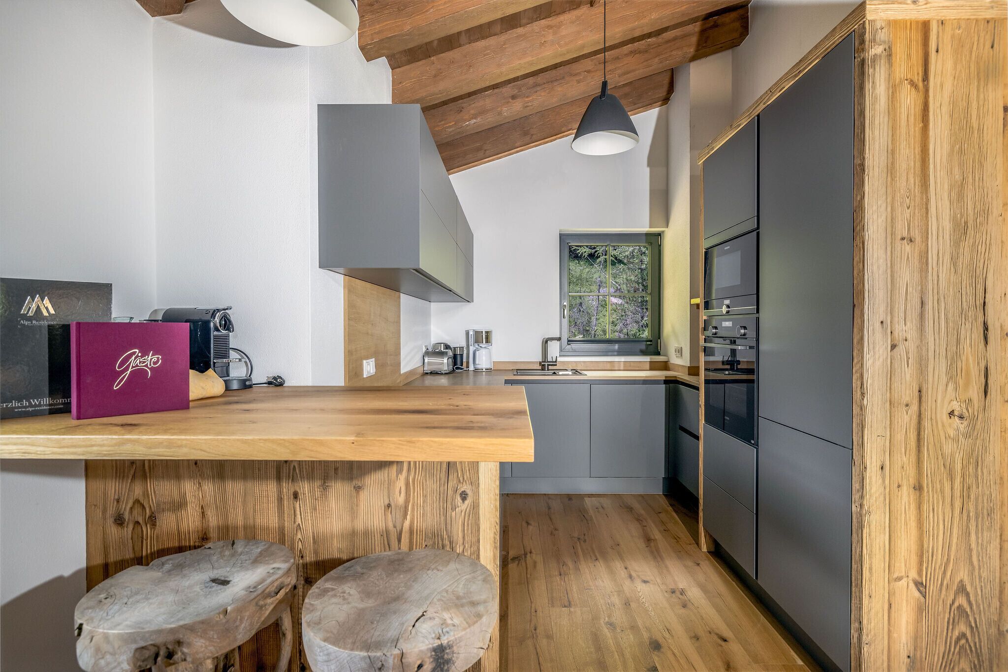 A modern kitchen with wooden beams, a wooden countertop, and a built-in oven.