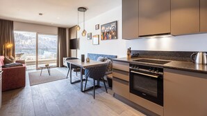 A modern kitchen with a built-in oven and a dining area with a table and chairs.