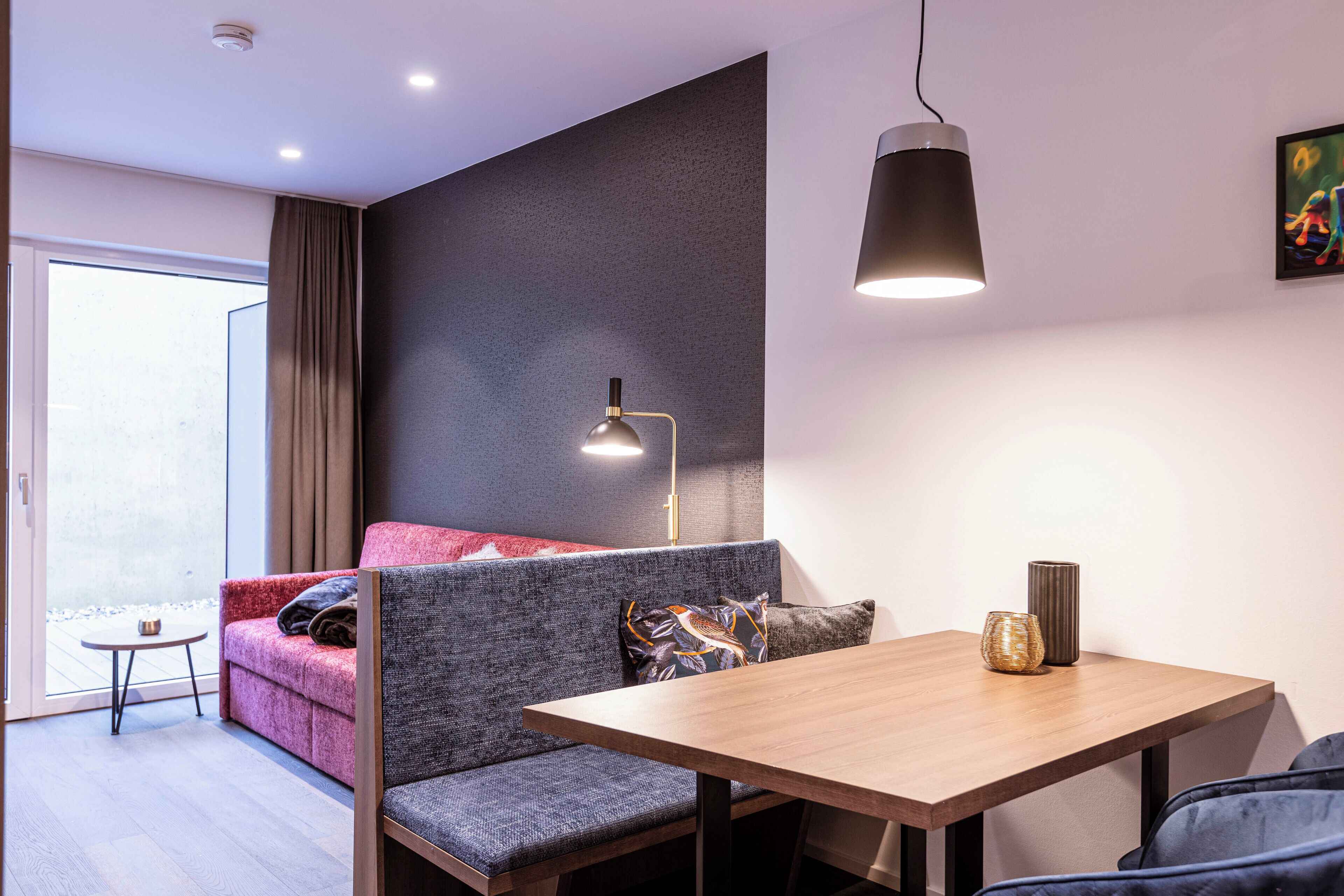 Une pièce moderne avec un canapé, une table et une lampe.