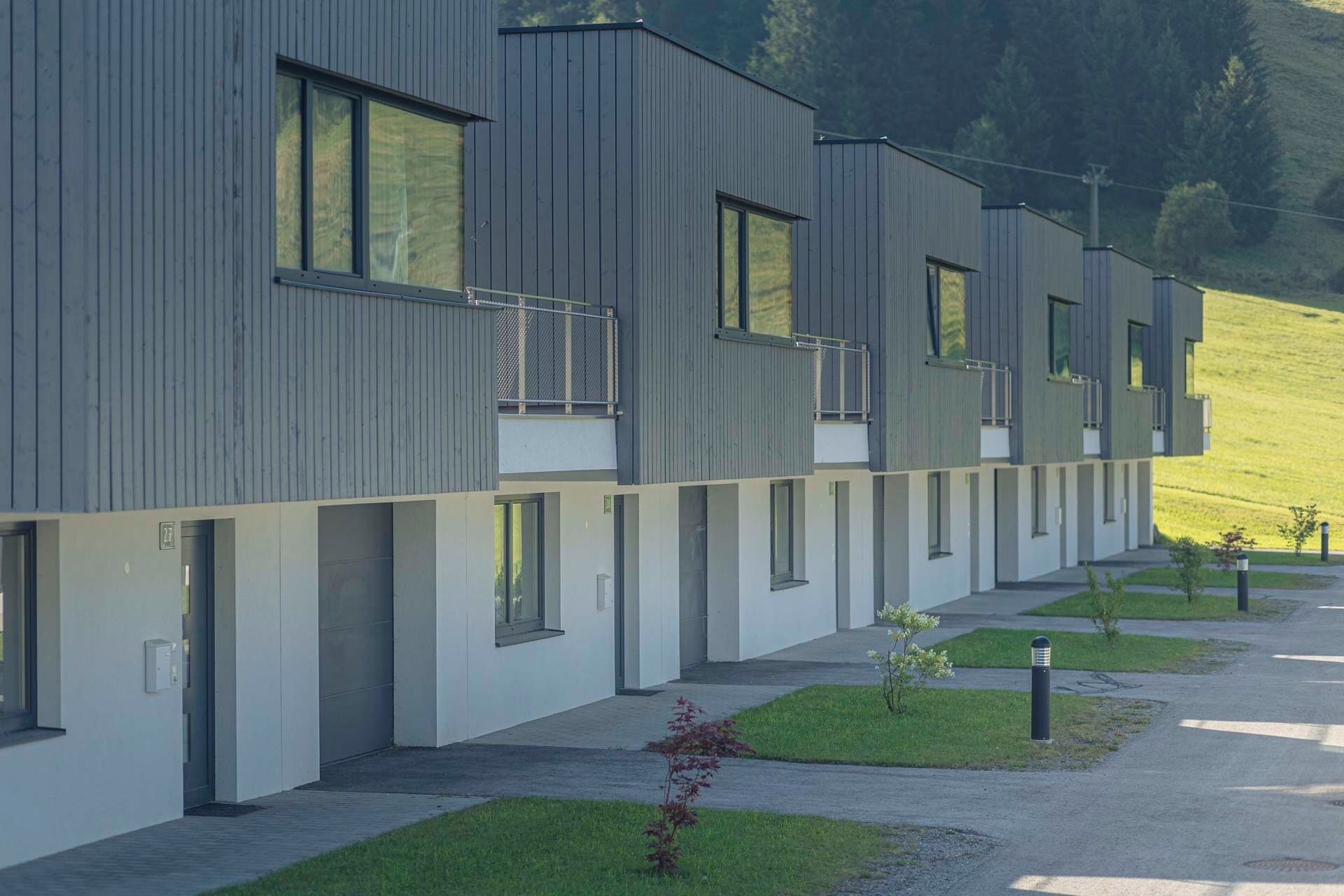 Un edificio moderno de varios pisos con fachada lineal, ventanas amplias y techo plano.