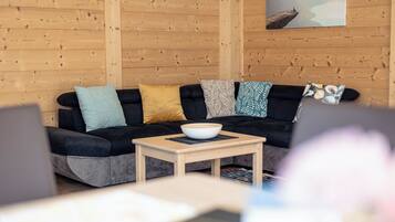 A cozy living area with a black sofa, a wooden coffee table, and a bowl on it.