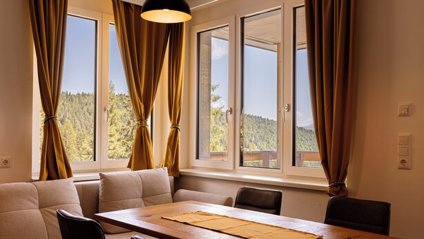 A dining area with a wooden table, four chairs, and a sofa. - Turrach Suites 410 by ALPS RESORTS (Stadl-Predlitz)