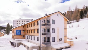 A multi-story hotel with a modern design, featuring balconies and a ski resort sign. - Turrach Suites 410 by ALPS RESORTS (Stadl-Predlitz)