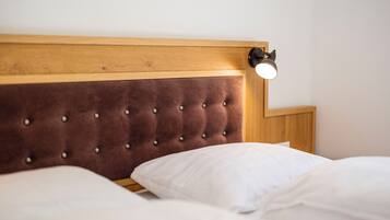 A bed with a wooden headboard and a bedside lamp.