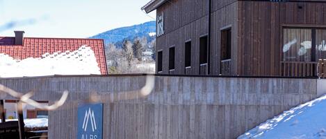 A building with a sign for 'ALPS RESORTS' and a snow-covered slope.
