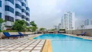 A swimming pool with blue water, surrounded by lounge chairs and a tiled deck. - Direct Rooms at Omni Complex Nana (Bangkok)