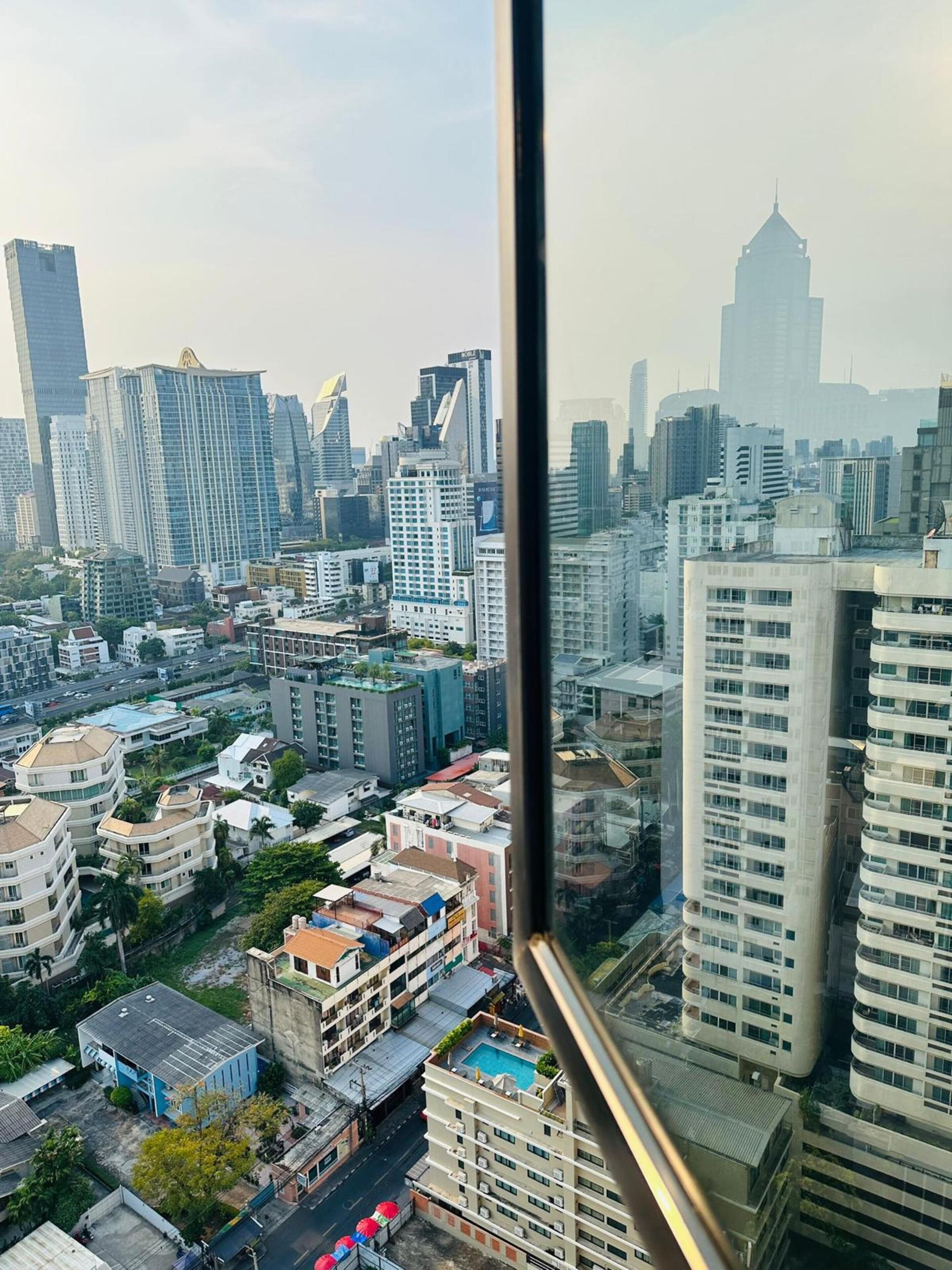 Paisagem urbana com edifícios altos, incluindo um arranha-céu imponente com topo pontudo.