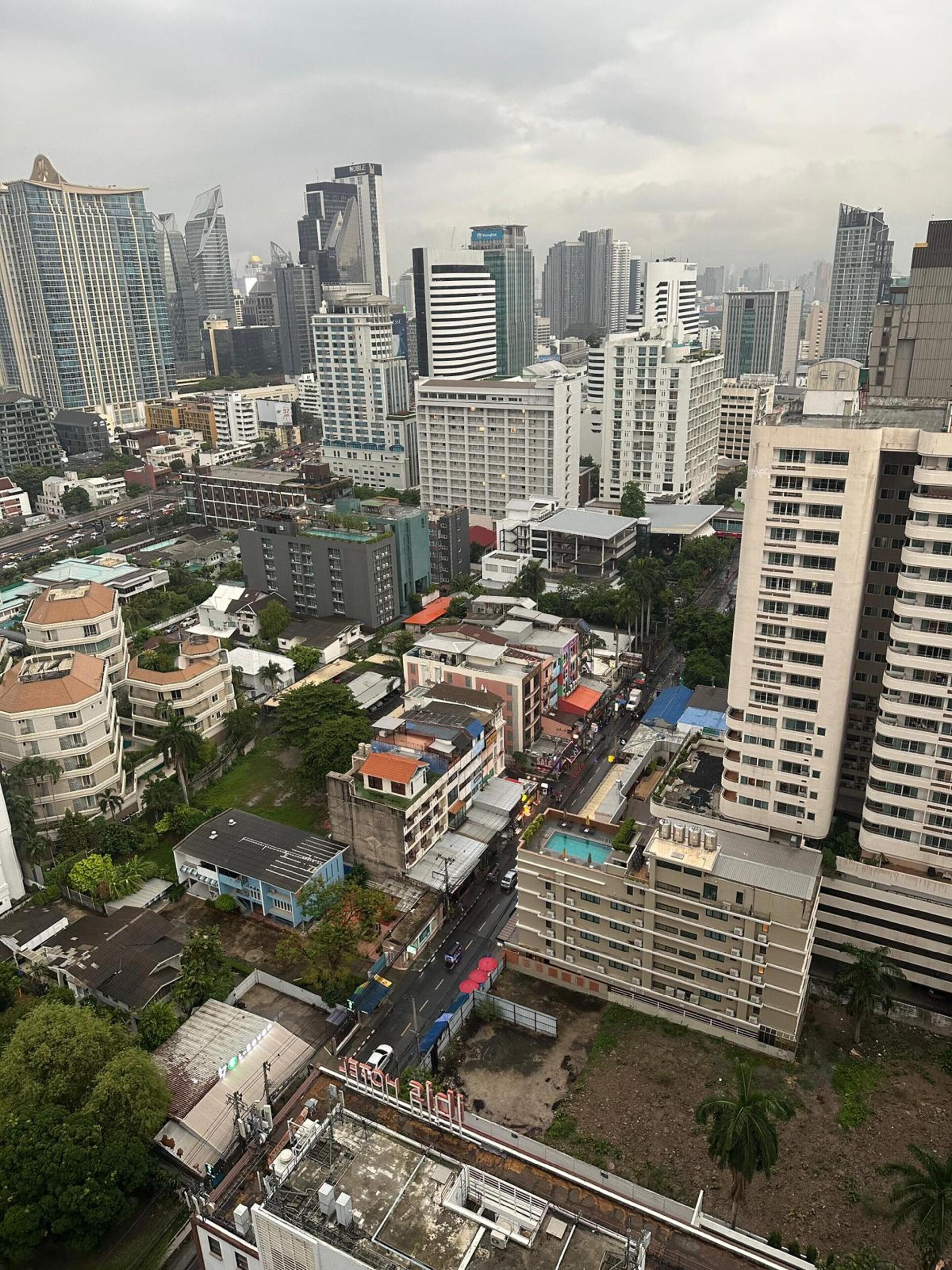 A cityscape with high-rise buildings, a mix of residential and commercial structures, and a prominent bridge.